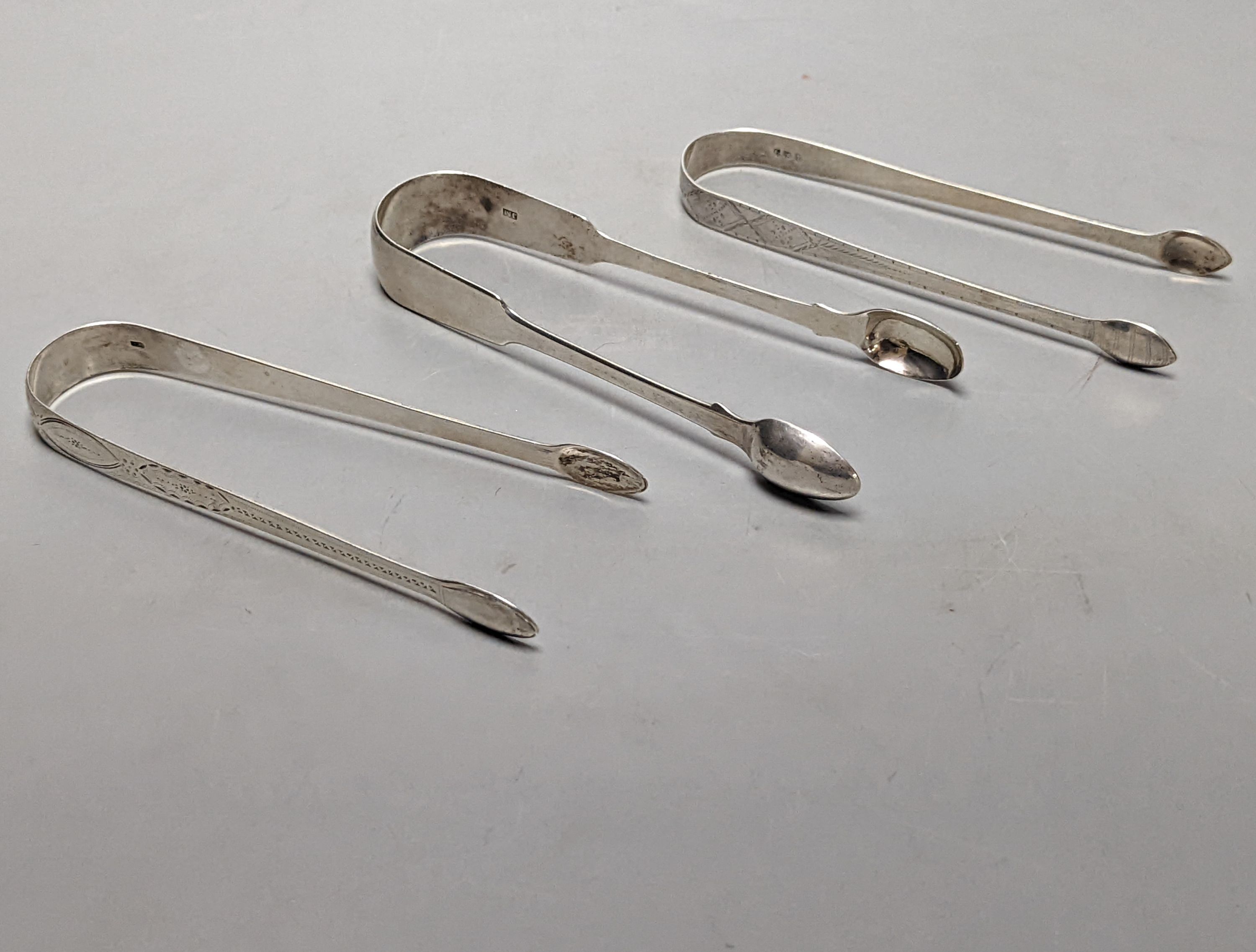 Two pairs of George III bright cut engraved silver sugar tongs and a pair of George IV silver sugar tongs, various dates and makers